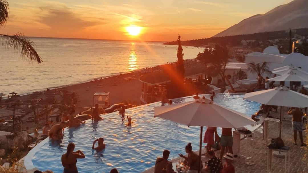 White pebble beach and clear water at a beach club in Dhermi on the Albanian Riviera