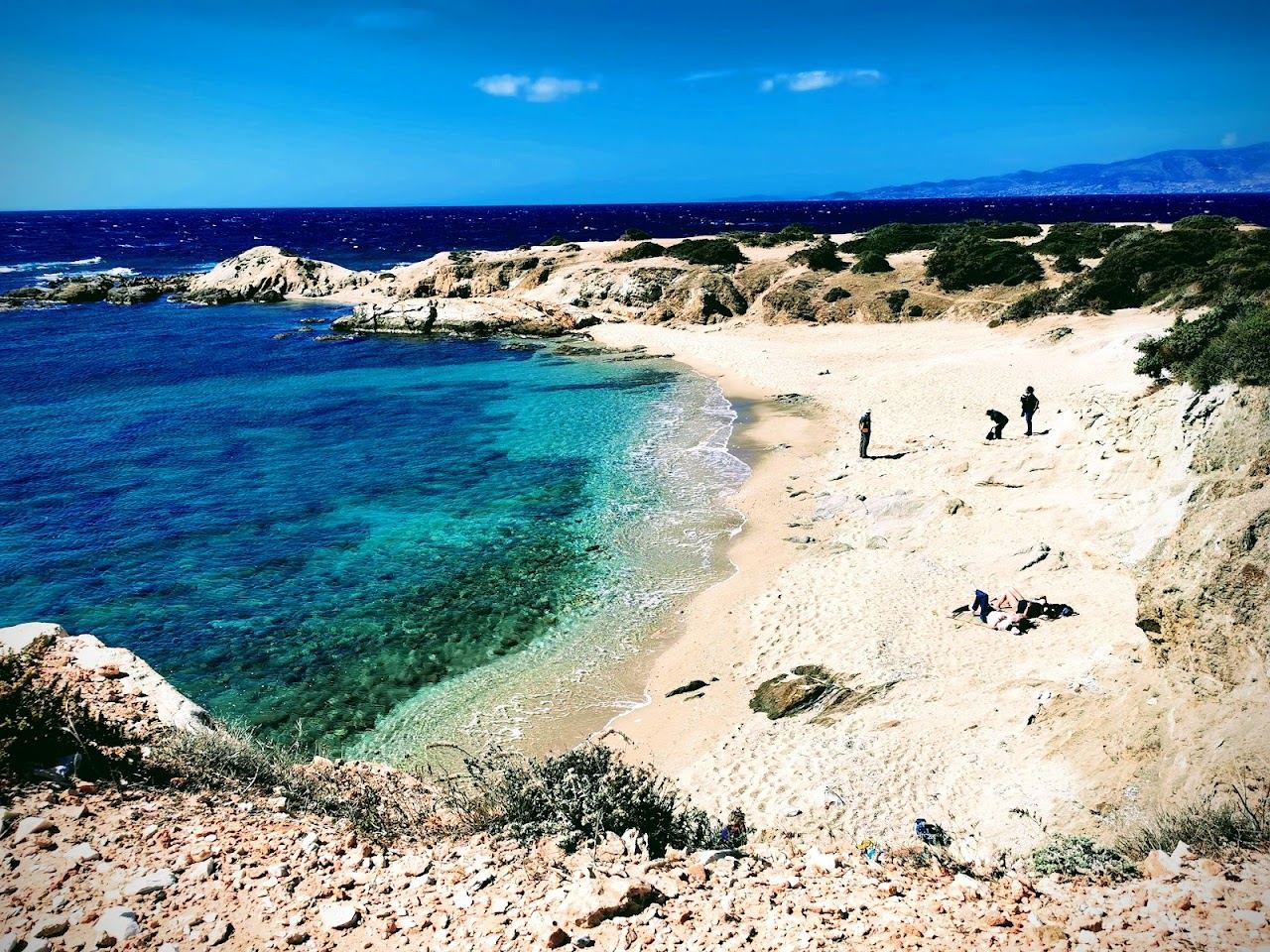 Turquoise water and pale sand backed by a cedar forest at the quiet southern coves of Alyko in Naxos