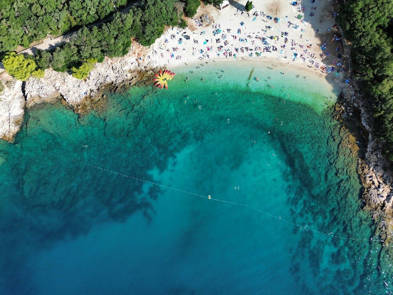 Clear blue water and pebble shore at Ambrela beach on the Verudela peninsula near Pula