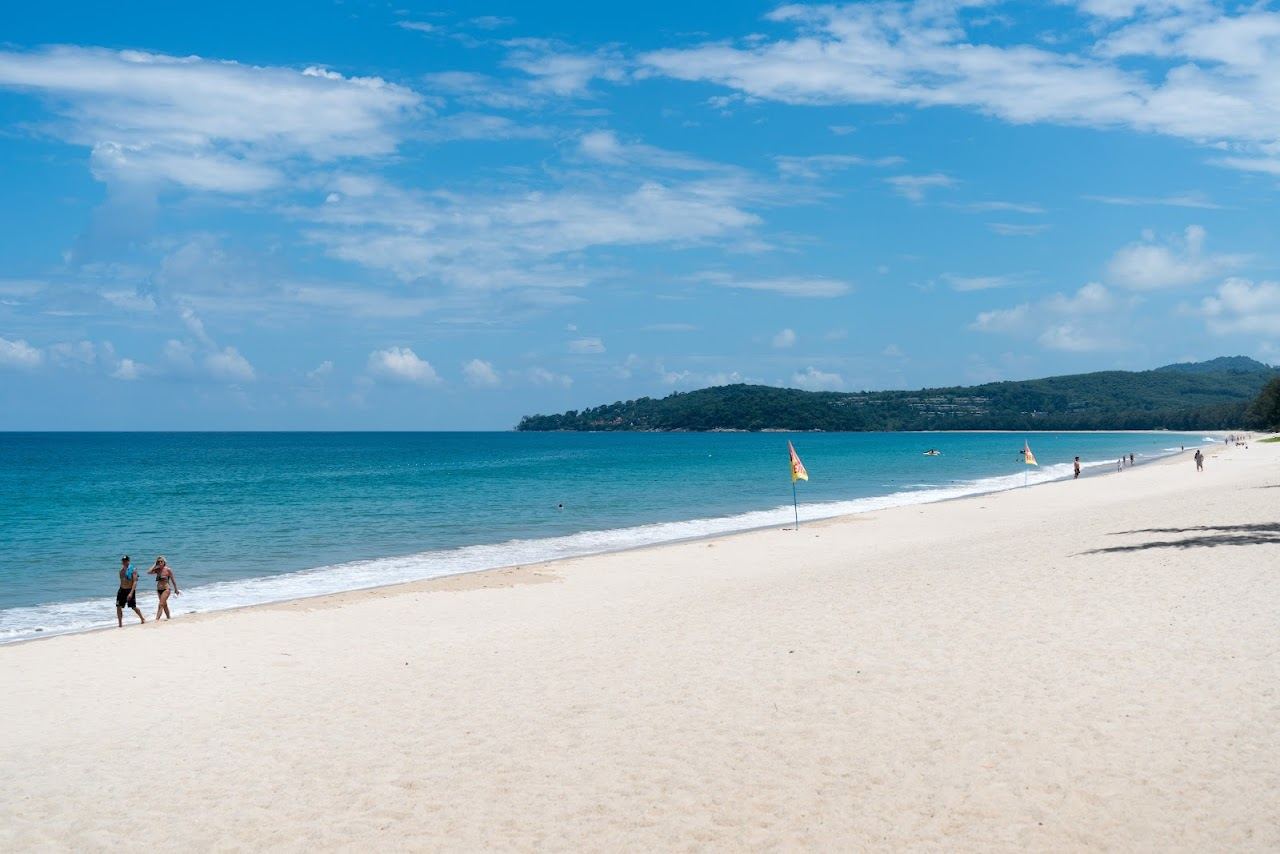 Long west coast curve of sand at sunset on Bang Tao beach in Phuket