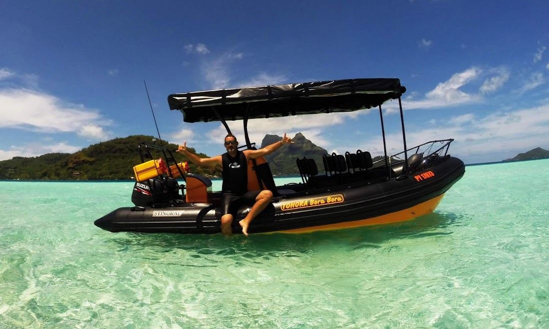 A reef manta ray gliding over coral in the Bora Bora lagoon near Anau
