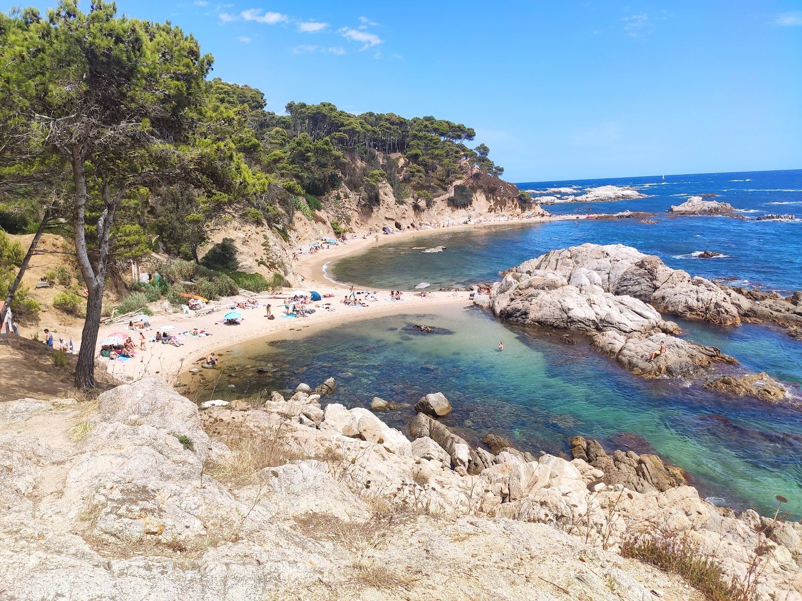 Rocky headland and clear shallows at the secluded Cala Estreta near Palamos on the Costa Brava