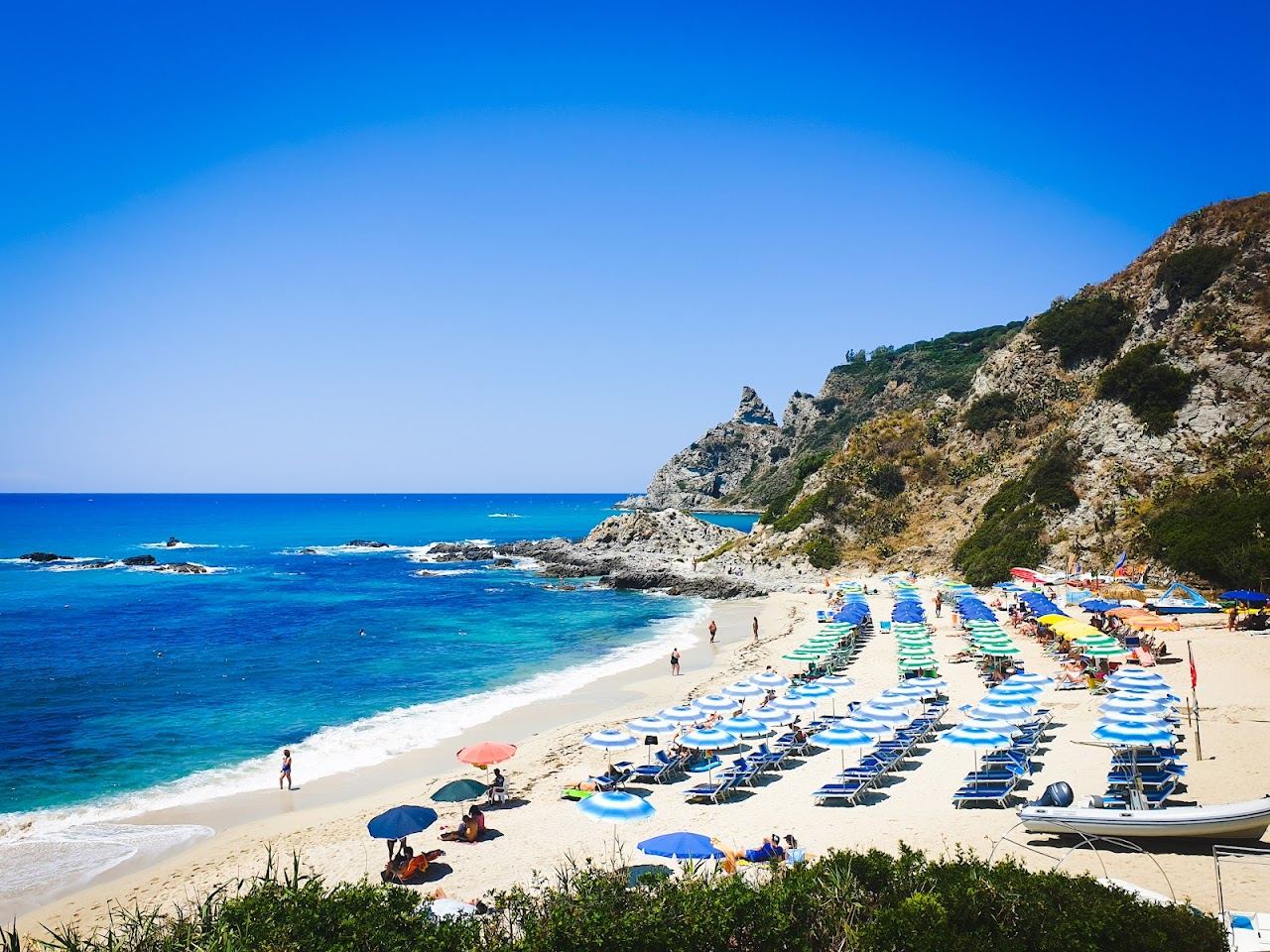 Clear turquoise water over a sandy cove below the cliffs at Capo Vaticano in Calabria