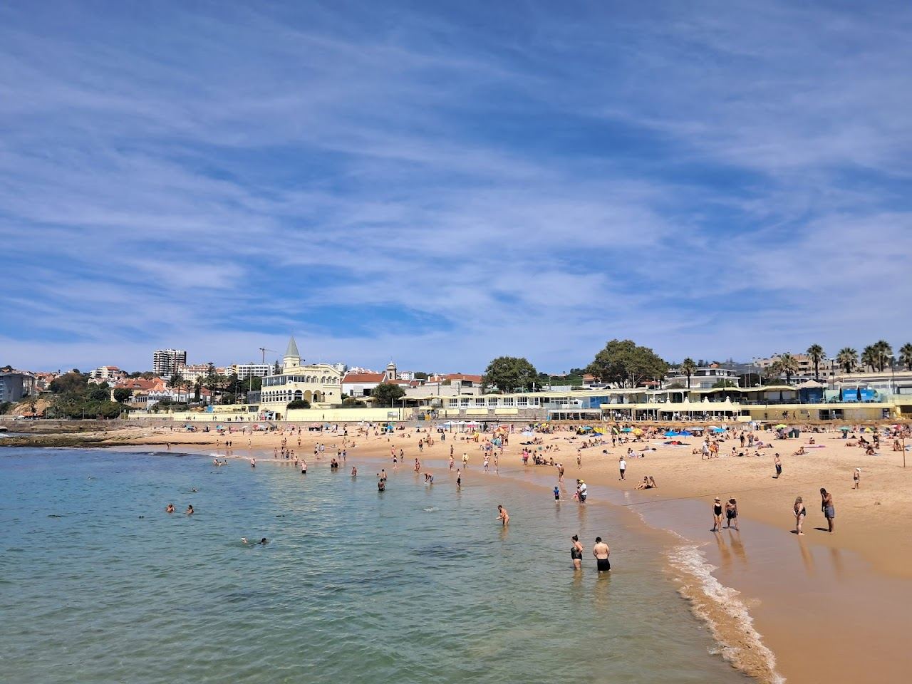 Seafront promenade and cafes behind the sand at Praia do Tamariz in Estoril