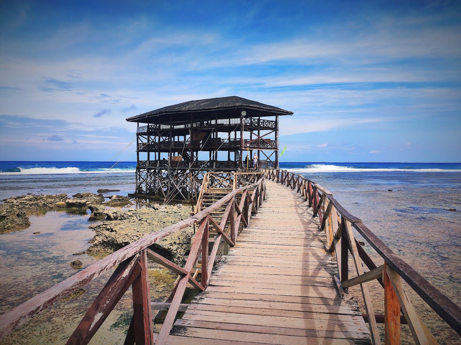 The long timber boardwalk and viewing tower reaching over the reef break at Cloud 9 in Siargao at dawn