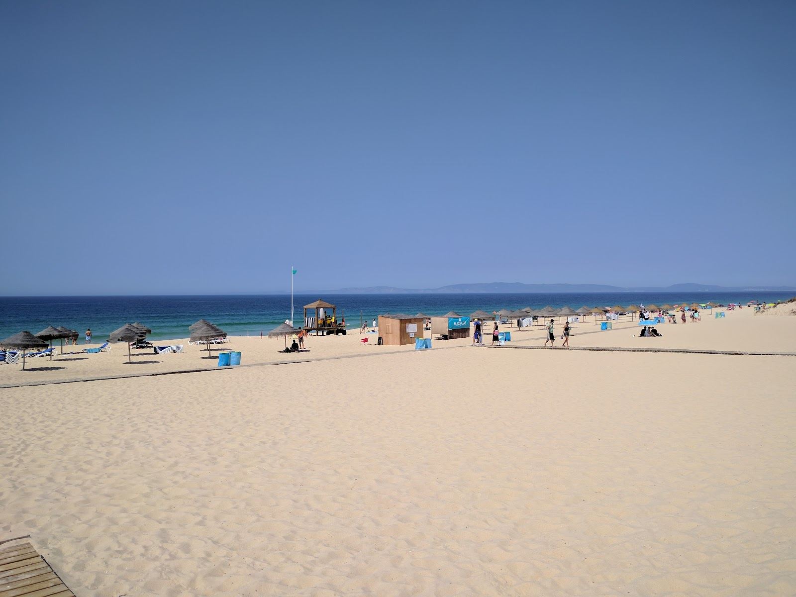 Wide empty Atlantic sand backed by dunes and pines on a Comporta beach at golden hour
