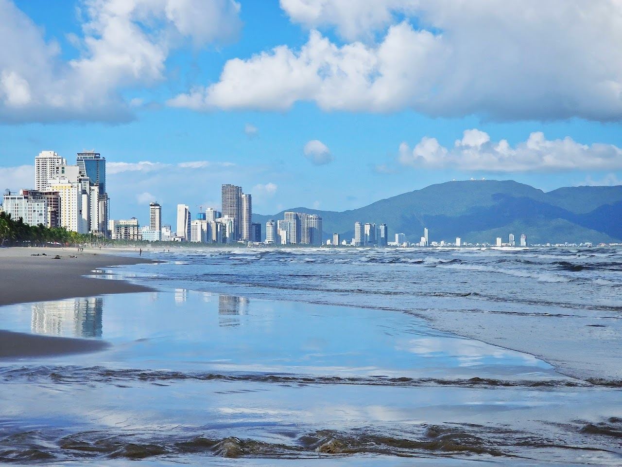 Long golden sand and gentle surf along My Khe beach in Da Nang, Vietnam