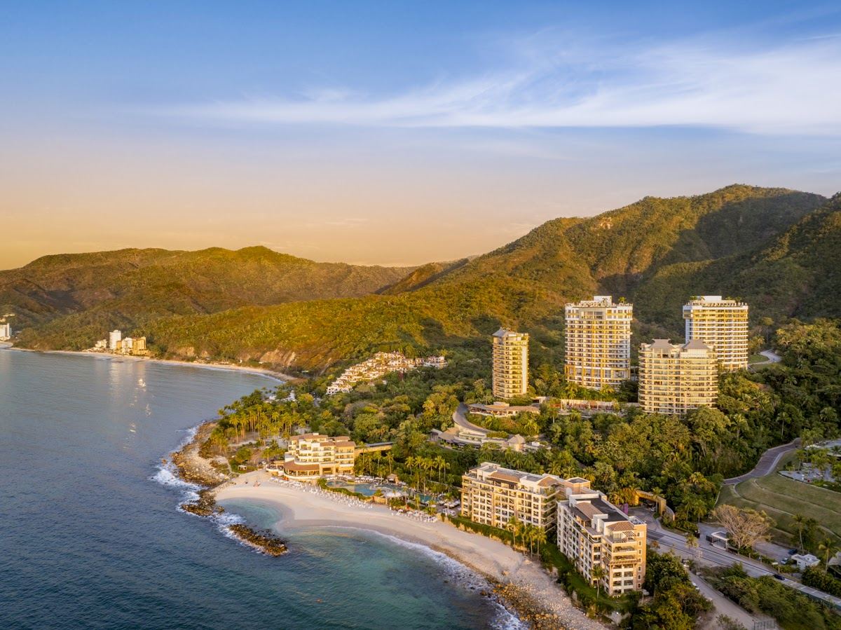 The small golden cove and clear emerald water of Playa Garza Blanca below the jungle