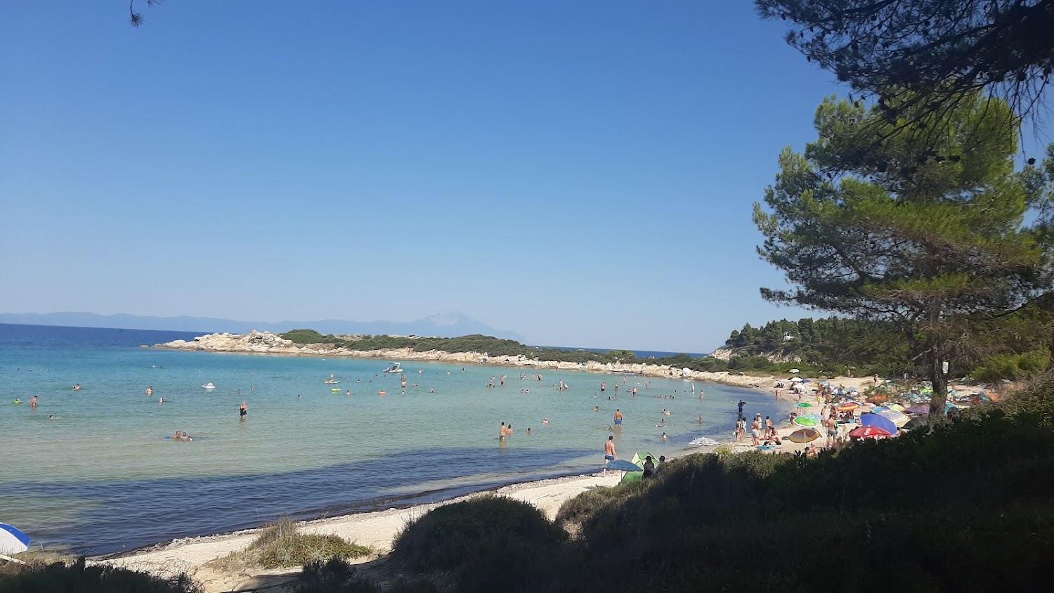 Sheltered shallow turquoise water and islets at Vourvourou, a calm swimming bay on Sithonia in Halkidiki