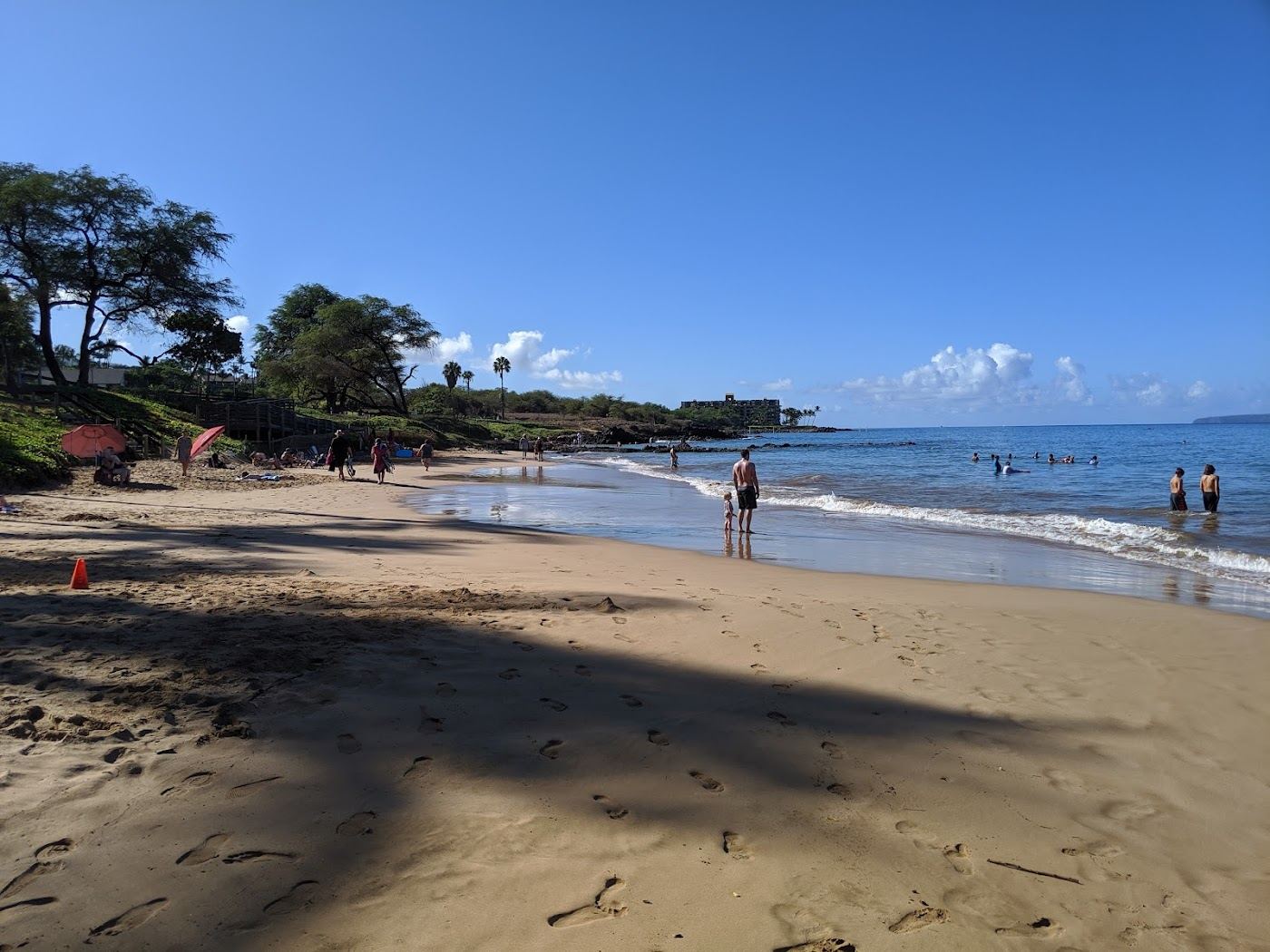 The grassy park and calm swimming water of Kamaole Beach in Kihei town on Maui