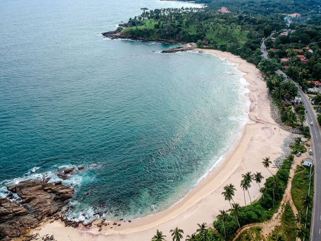 Hiriketiya Beach horseshoe cove with calm inner bay and palm headland on the Sri Lanka south coast