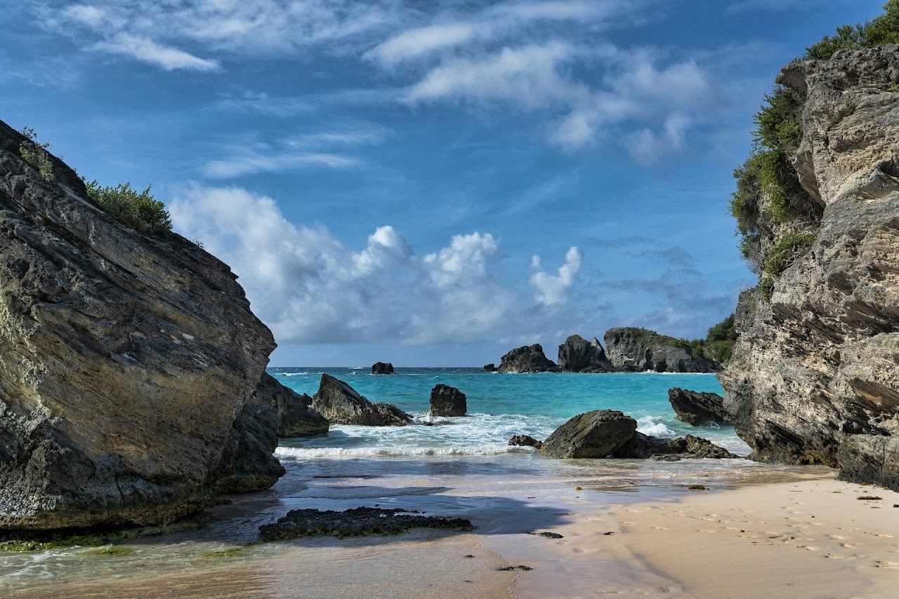 The curving pink sand and turquoise water of Horseshoe Bay framed by limestone outcrops in Southampton, Bermuda