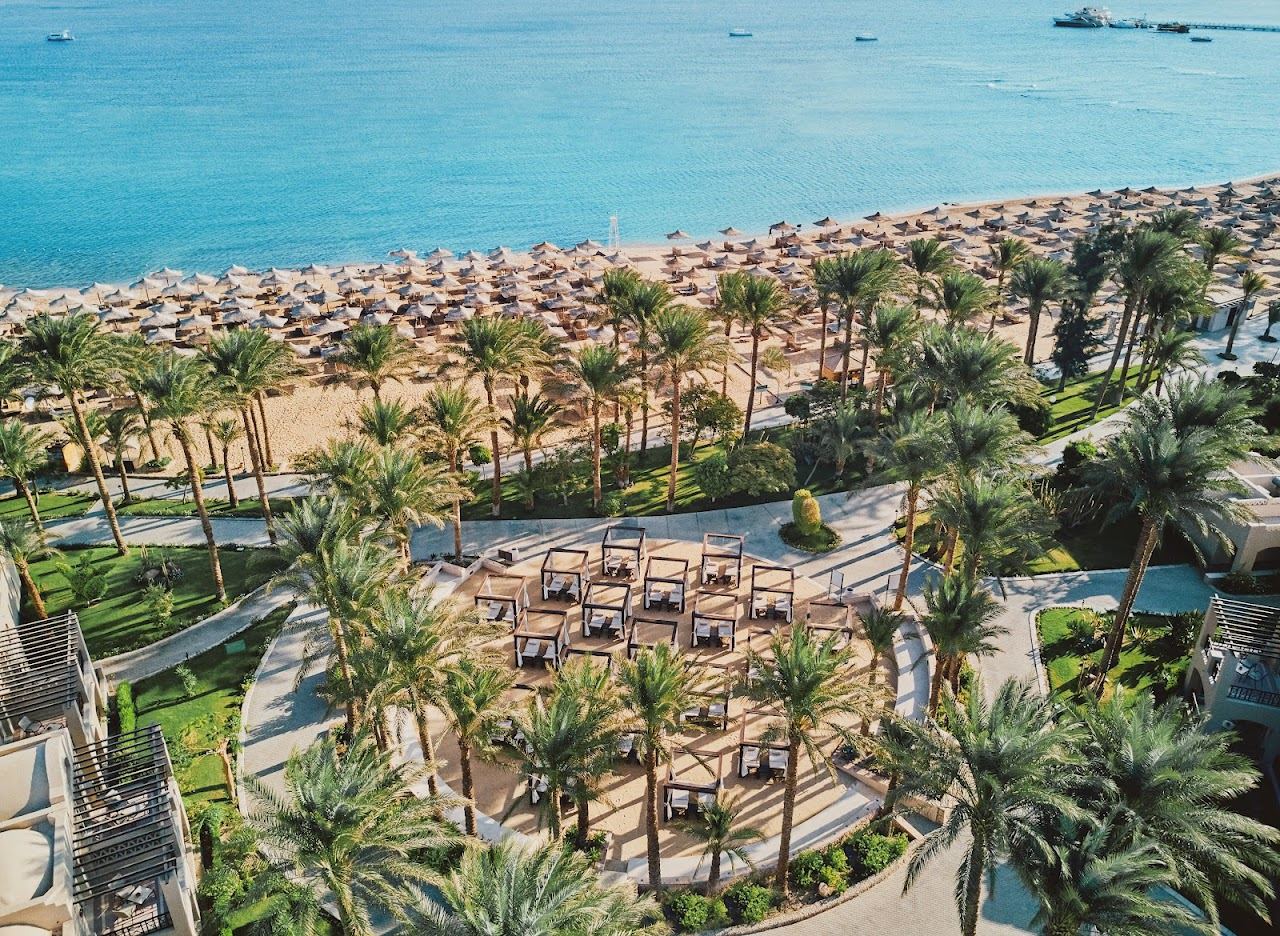 A wide soft sand resort beach with loungers and calm shallow water at Makadi Bay near Hurghada