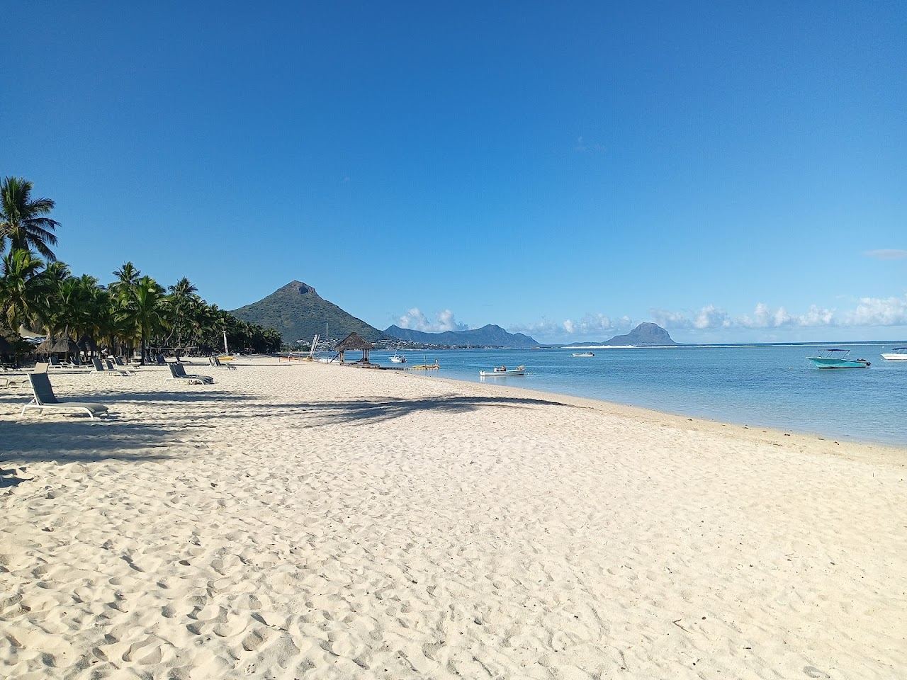 The long west coast beach and calm lagoon at Flic en Flac in Mauritius at sunset