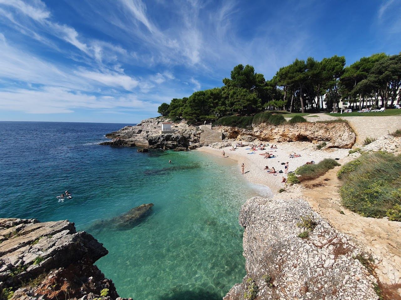 The clear turquoise water and low cliffs of Hawaii Beach near Pula, popular for diving and snorkelling in Istria