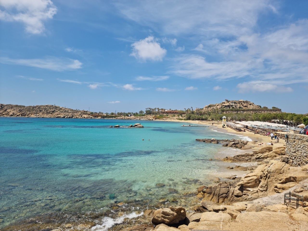 The sheltered Paraga cove with clear water and a rocky headland on the south coast of Mykonos