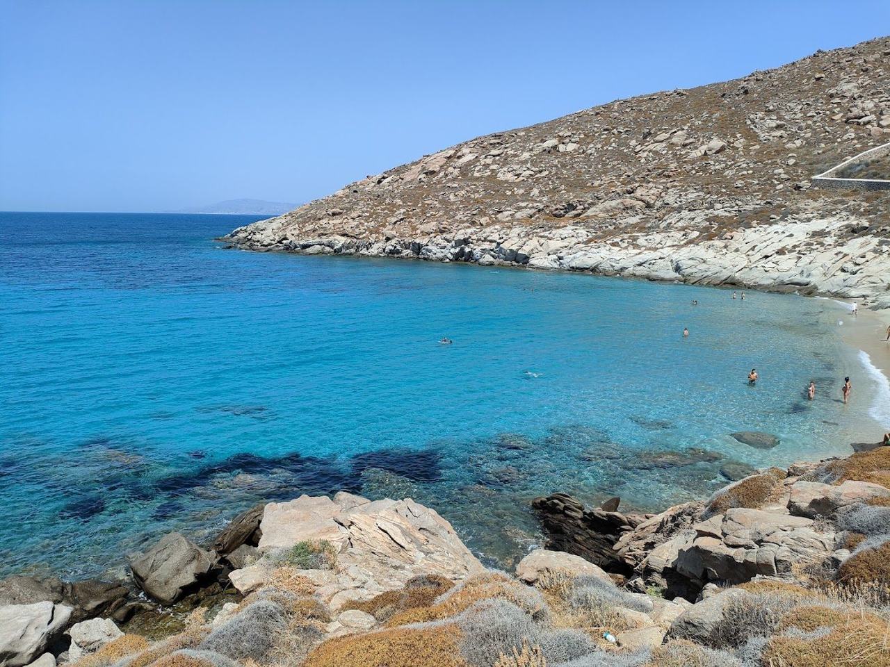 Clear shallow water and rocks framing the quiet Kapari cove on the southwest coast of Mykonos