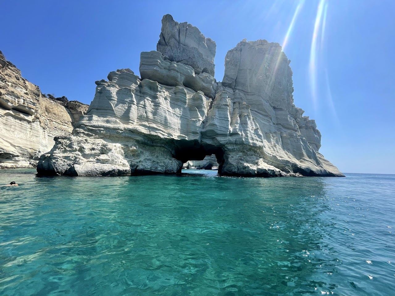 The white sculpted sea caves and arches of Kleftiko rising from clear turquoise water on the southwest coast of Milos