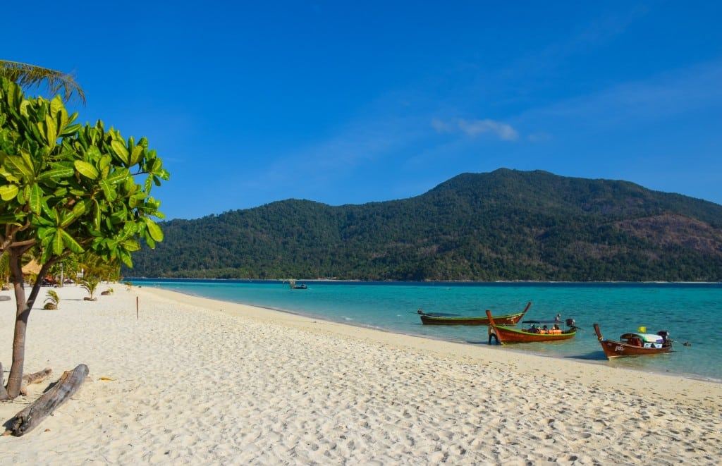 The calm turquoise shallows and soft pale sand of Sunrise Beach on Koh Lipe
