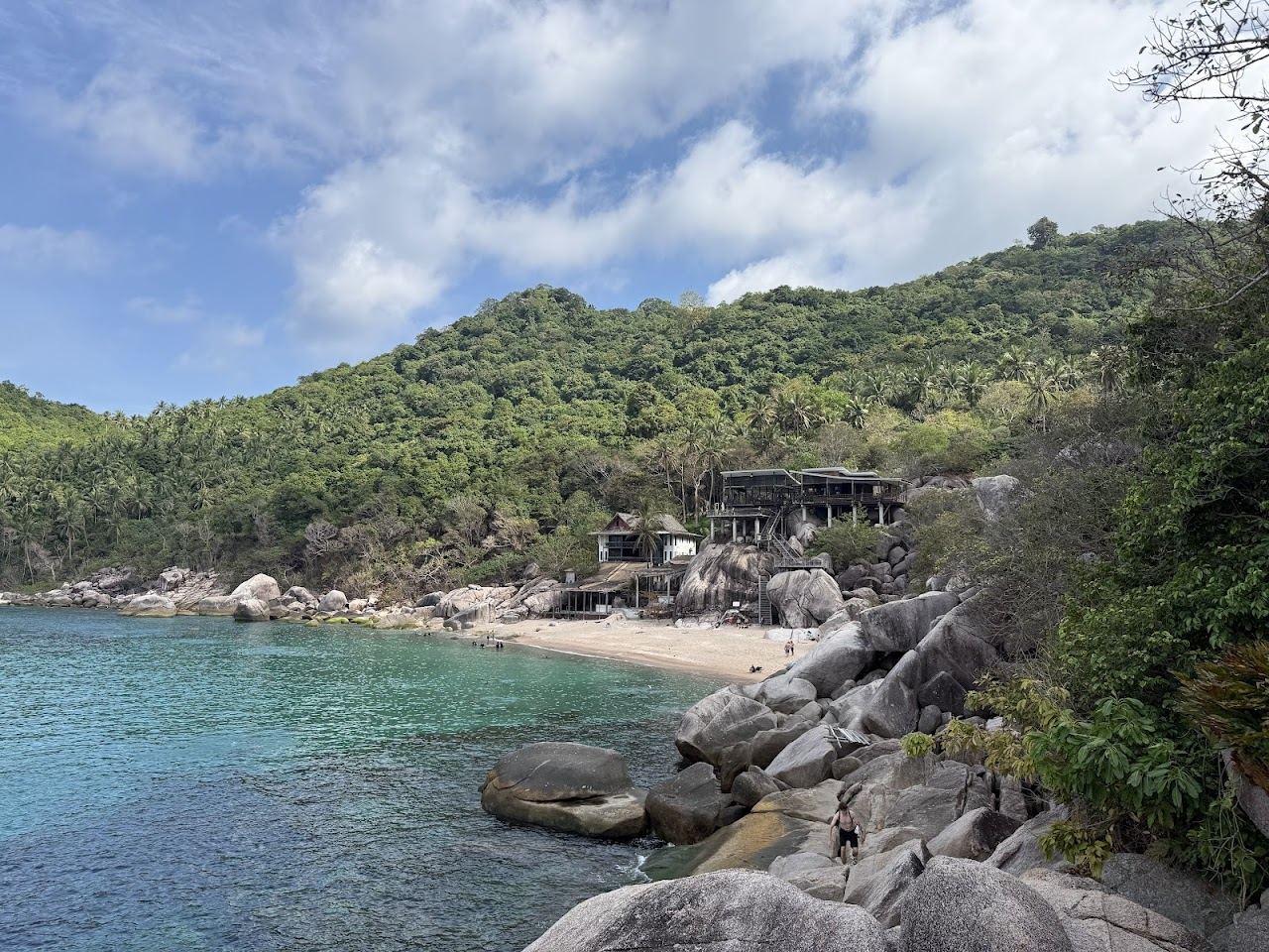 Rock framed cove with clear water and forest above at Mango Bay on Koh Tao