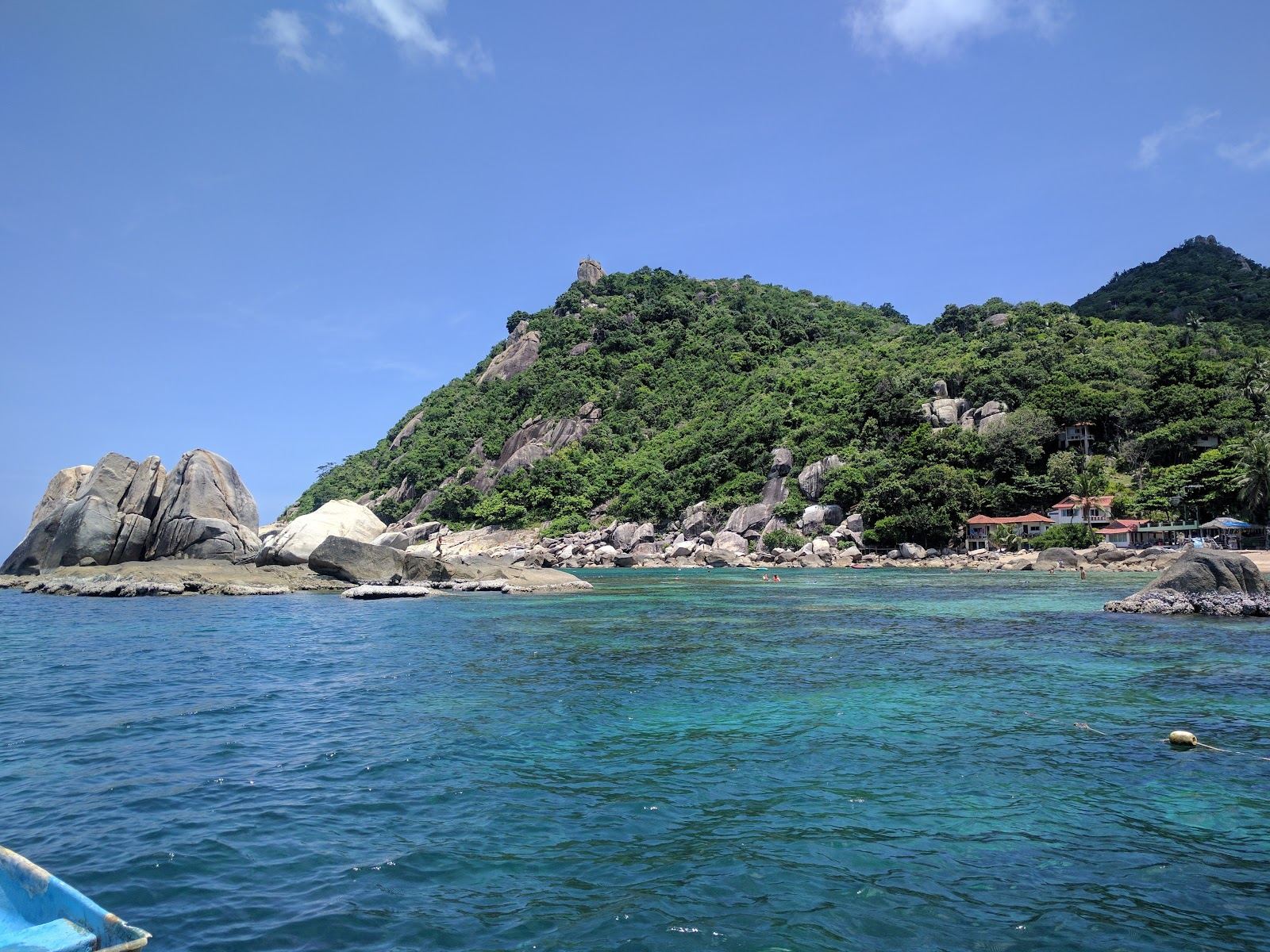 The white crescent sand and clear water of Tanote Bay with its offshore rock on the east coast of Koh Tao