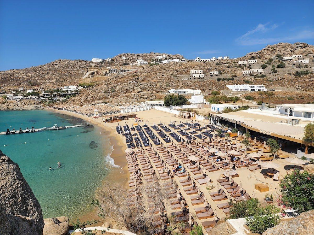 Daybeds and clear water at a beach club on the island of Mykonos.