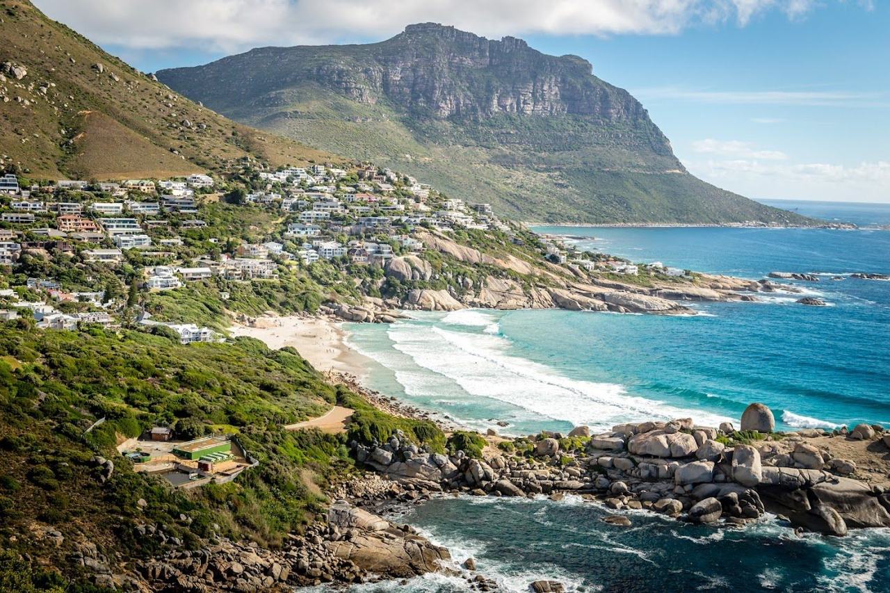 The sheltered white sand cove of Llandudno framed by granite boulders and mountains in Cape Town