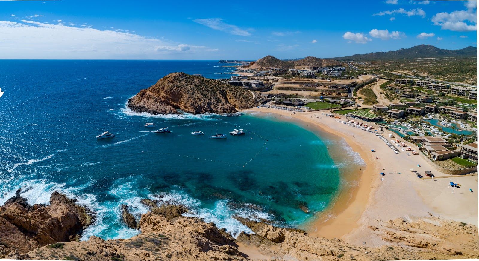 A quiet cove of pale sand between granite headlands on the Los Cabos coast.