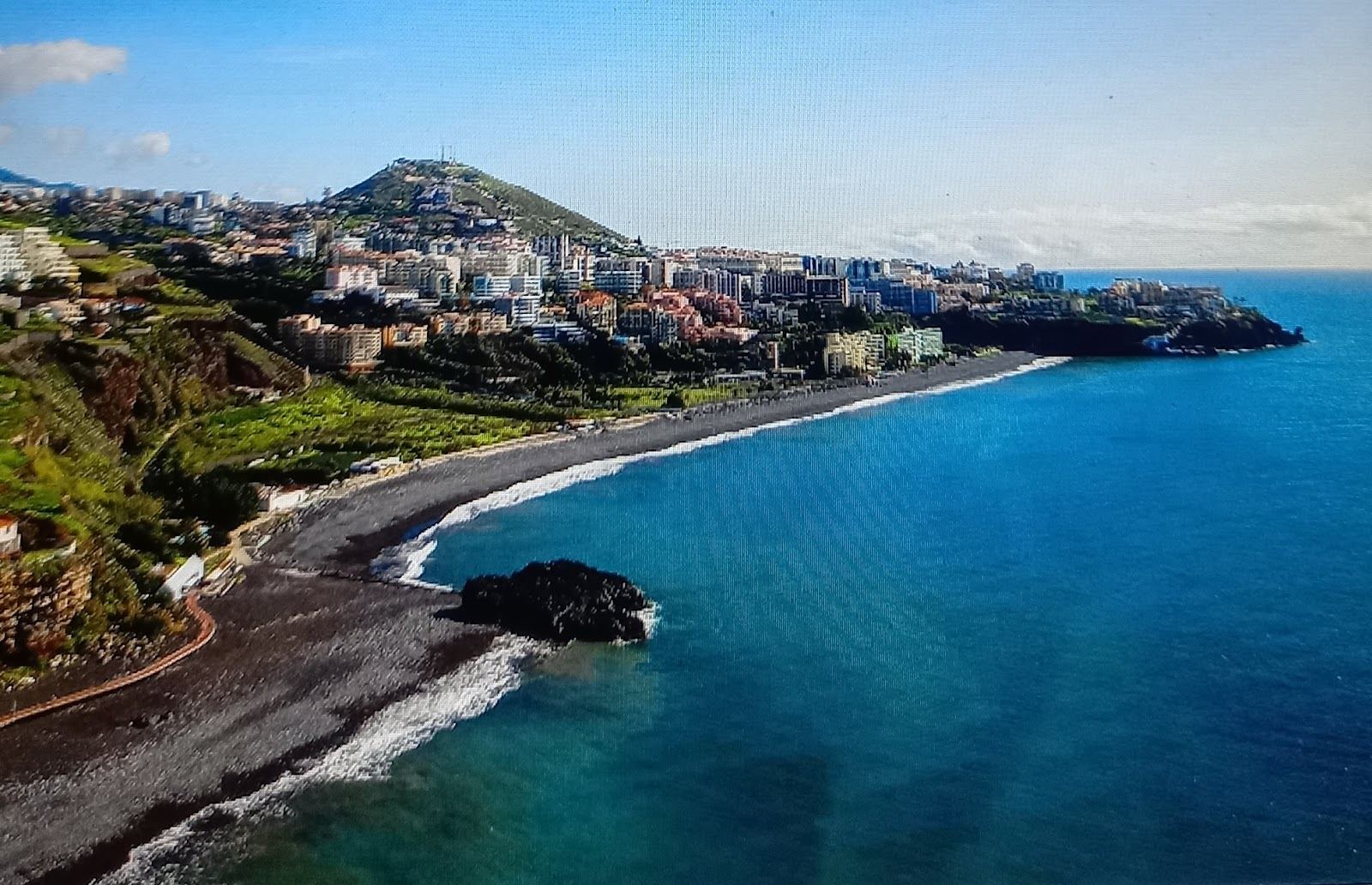 Dark sand and pebble shore with Atlantic surf rolling into Praia Formosa on the Funchal coast of Madeira
