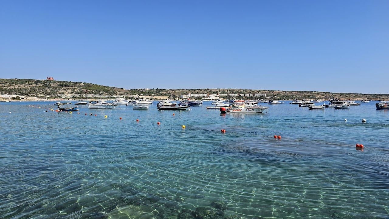 Shallow turquoise water and soft sand at a family beach in Malta