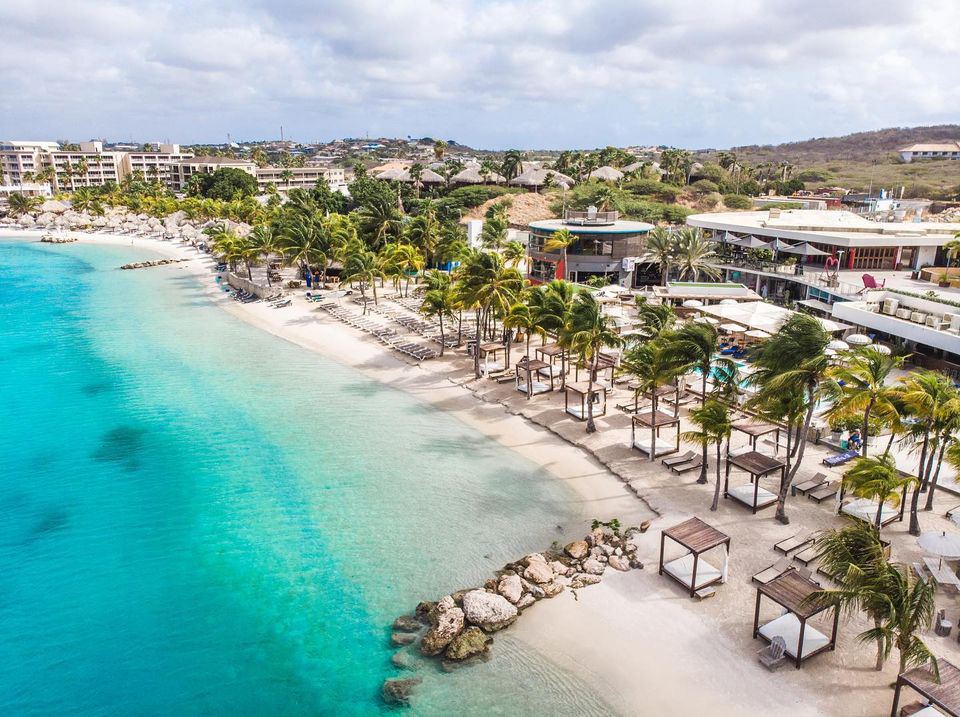 The two level Mambo Beach Boulevard behind the groomed sand and calm lagoon in Curacao