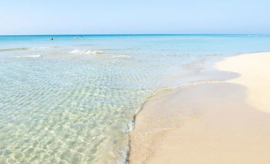 White sand and shallow turquoise water along the Maldive del Salento at Marina di Pescoluse, Puglia