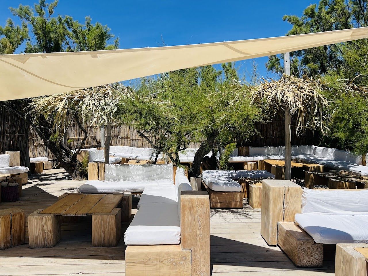 Tables and raffia parasols at Club 55 on Pampelonne beach, Saint Tropez