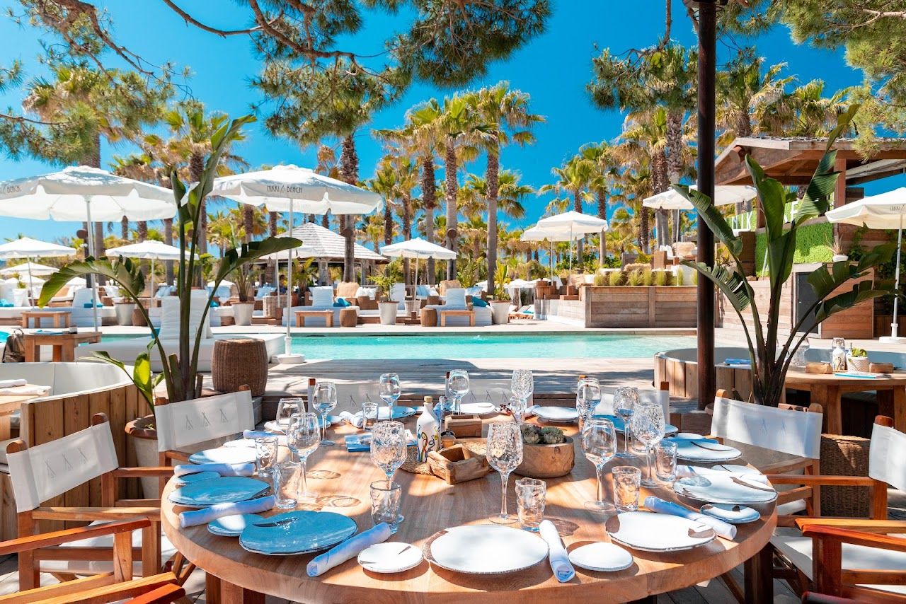 White daybeds and service on the sand at Nikki Beach, Saint Tropez