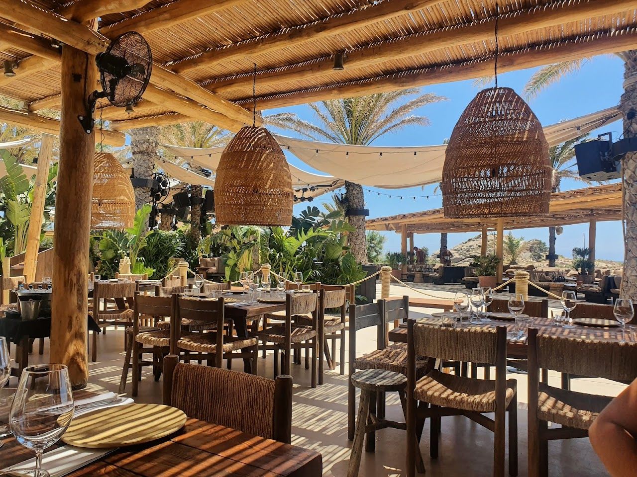 Driftwood daybeds and a sunset crowd at Scorpios on Mykonos
