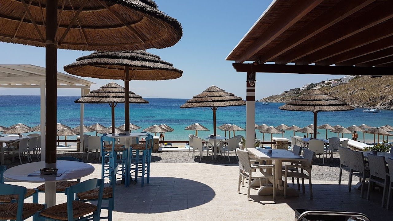 Yachts offshore and daybeds on the sand at Nammos on Psarou beach, Mykonos
