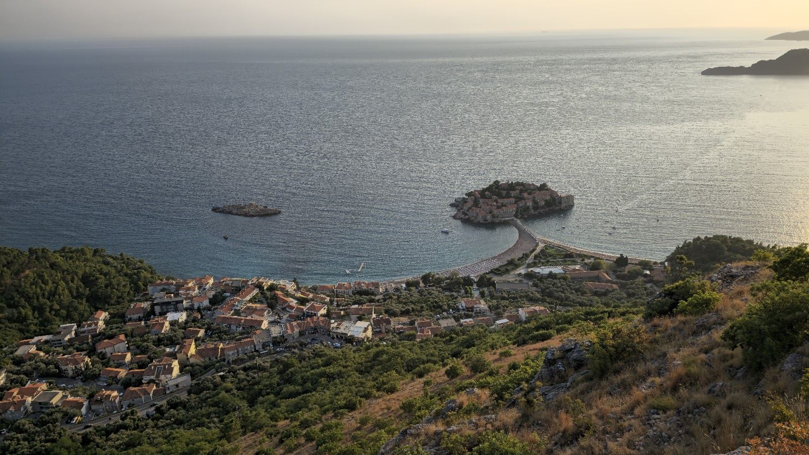 Clear turquoise Adriatic water and a pebble shore along the Montenegro coast near Budva
