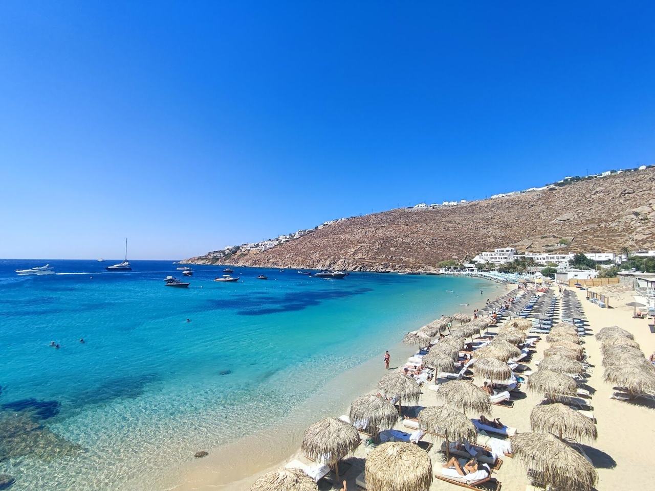 Whitewashed shoreline and blue water on a beach in Mykonos