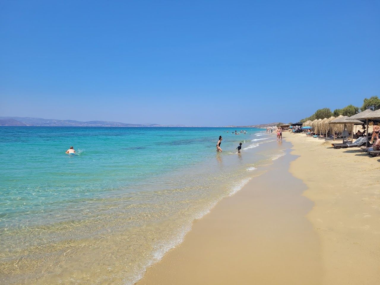 Long powdery white sand and calm clear water stretching along Plaka beach on the southwest coast of Naxos