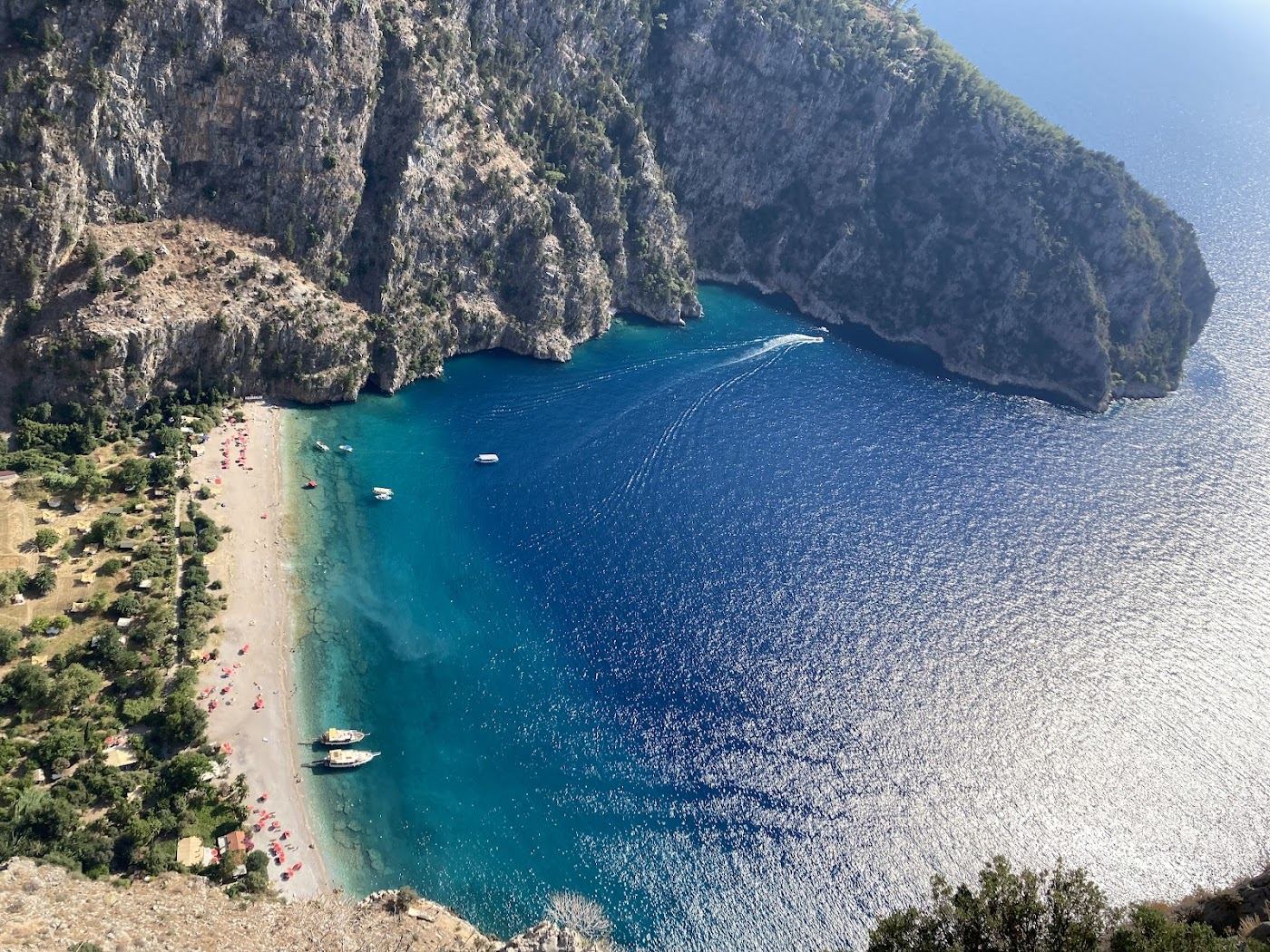The dramatic cove of Butterfly Valley walled by steep cliffs with a small pebble beach reached by boat from Oludeniz near Fethiye in Turkey