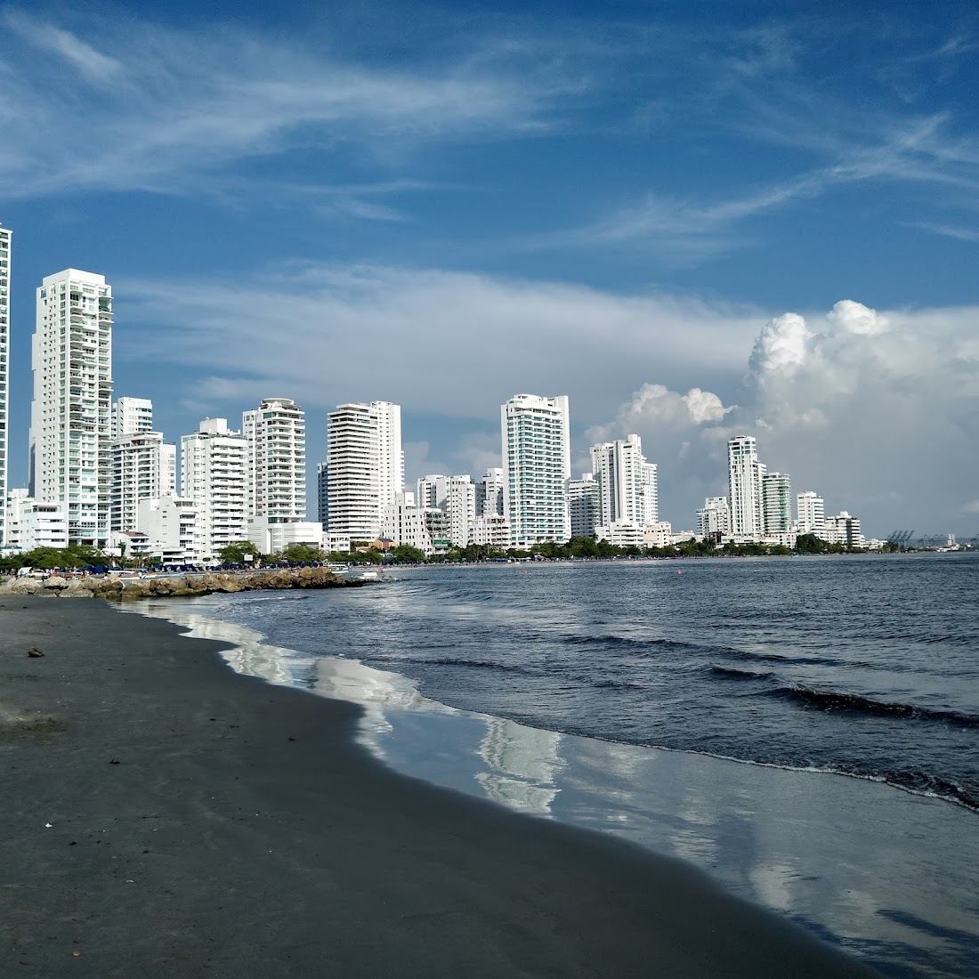 The calm bay water and city backdrop at Playa de Castillogrande in Cartagena