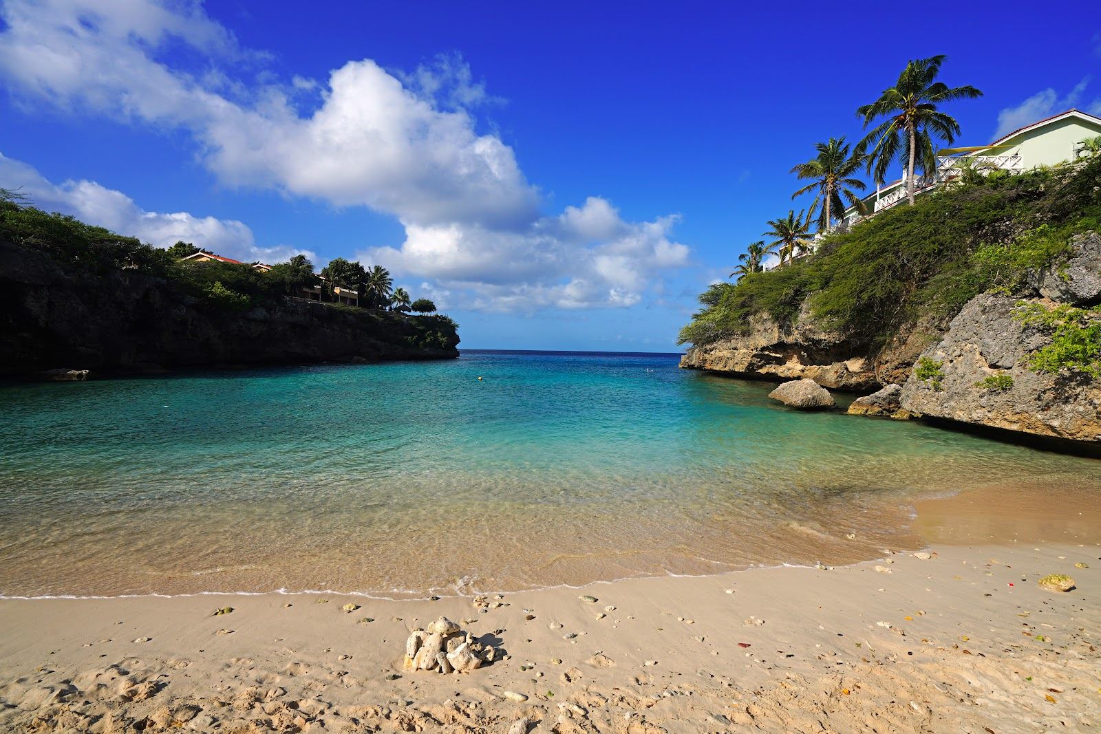 Clear calm water between rocky cliffs at Playa Lagun in Curacao, a sheltered snorkelling cove