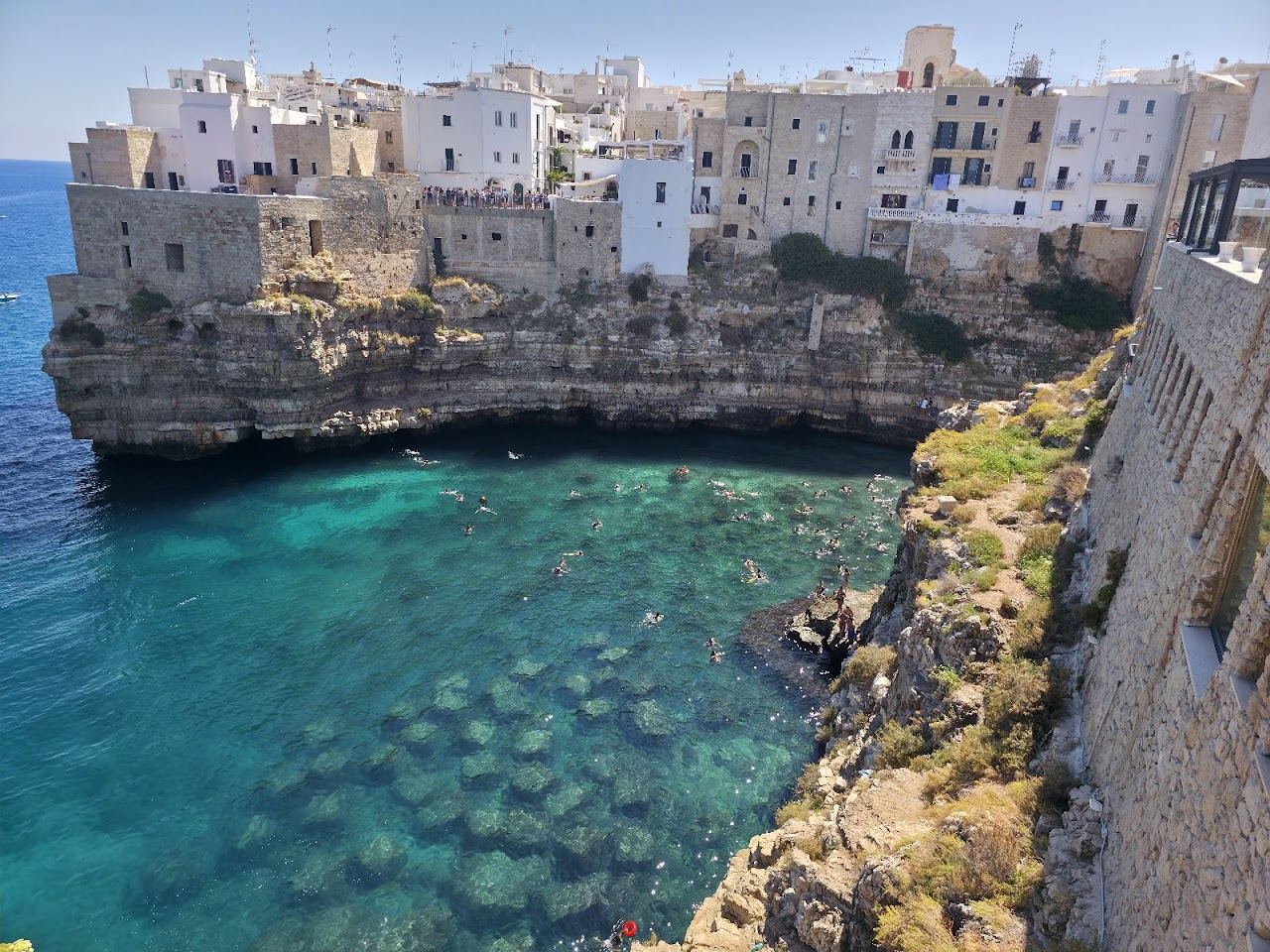 Clifftop houses above the clear Adriatic water and cove at Polignano a Mare, Puglia