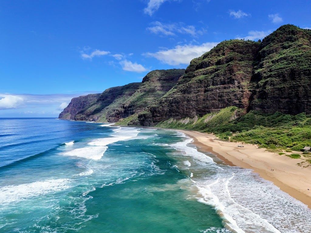Vast pale sand and high dunes below the cliffs at Polihale Beach on the west coast of Kauai