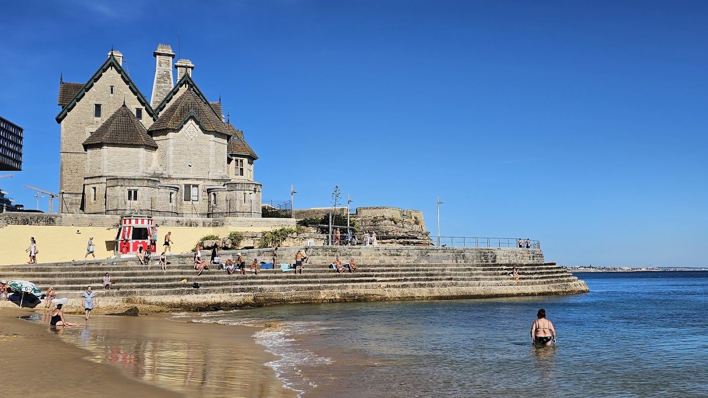 The sheltered town bay and promenade above the sand at Praia da Duquesa in Cascais