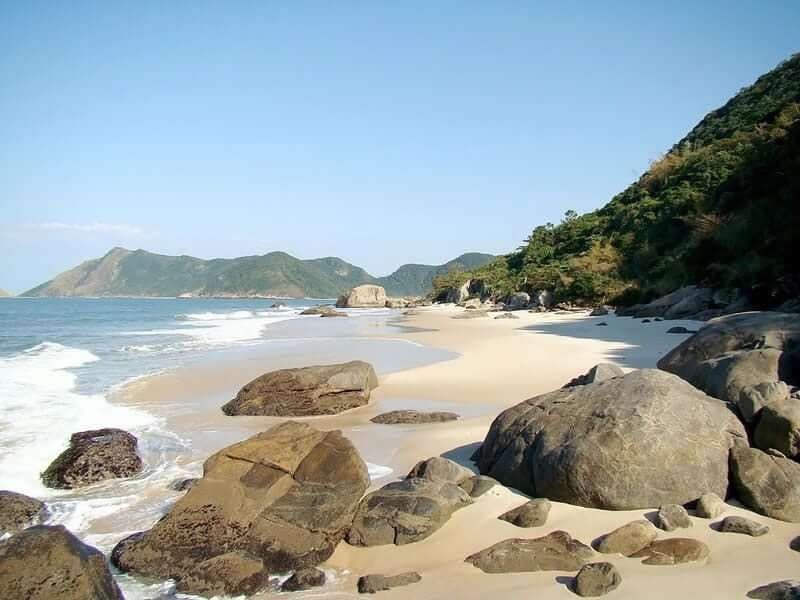 The wild undeveloped sweep of Grumari beach backed by green hills in west zone Rio de Janeiro