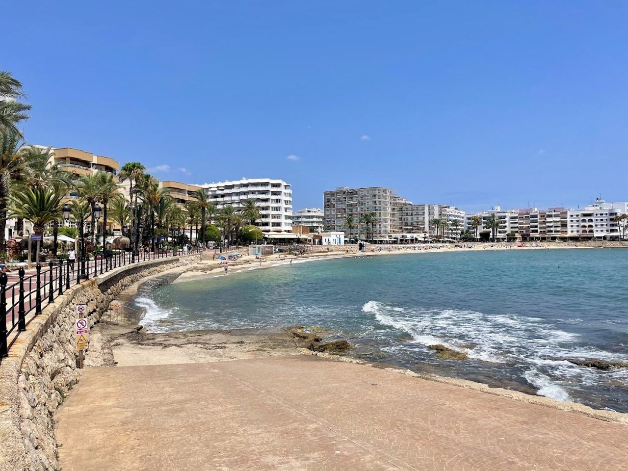 The long sandy town beach of Santa Eulalia and its palm lined promenade on the east coast of Ibiza