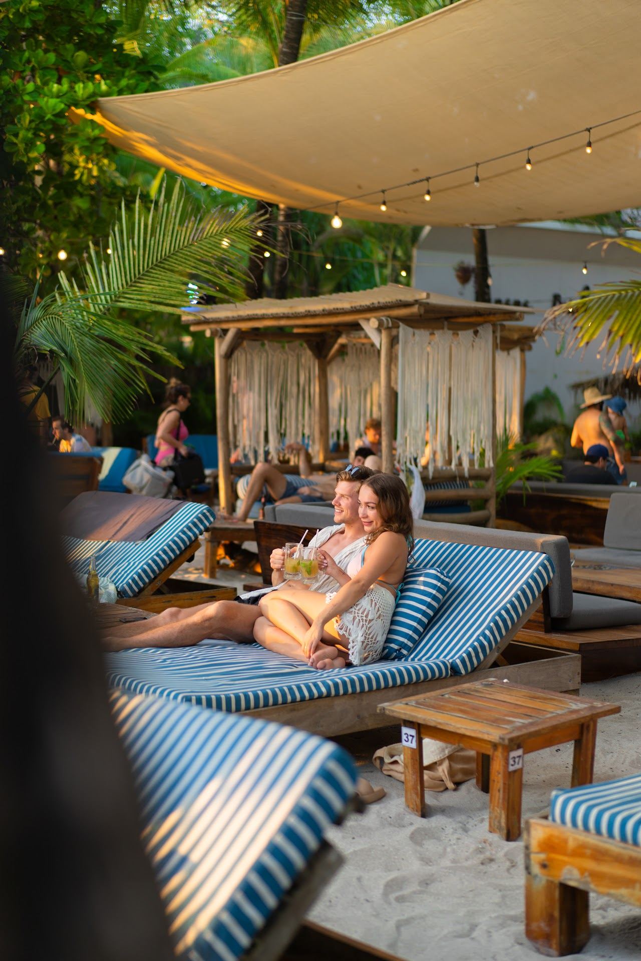 Beach bar tables and palms on the sand at sunset in Santa Teresa Costa Rica