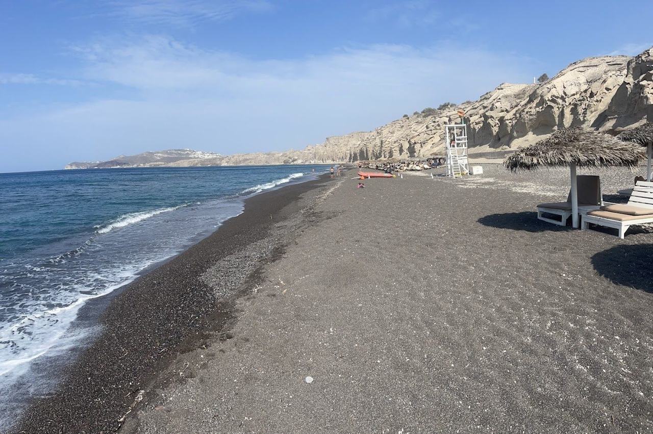 Sculpted pale cliffs above the quiet sand at Vlychada beach in Santorini