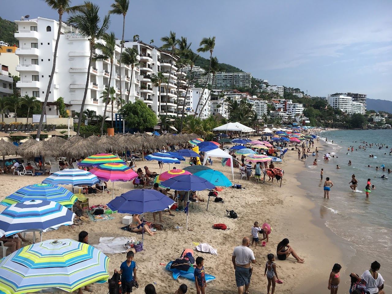 Calm sheltered cove with clear water and rocky headland at Playa de los Muertos in Sayulita